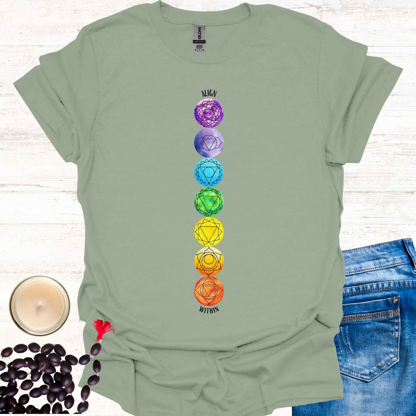 Sage green t-shirt featuring a colourful, vibrant design of the 7 chakras aligned vertically, each with its corresponding mandala symbol, accompanied by the phrase 'Align Within'. This design represents the energy centers within the body and emphasizes the importance of inner balance and harmony. Rooted in ancient wisdom, it inspires mindfulness, meditation, and self-reflection, aligning with themes of spiritual awakening and holistic well-being. Perfect for yoga practitioners and seekers of wisdom.