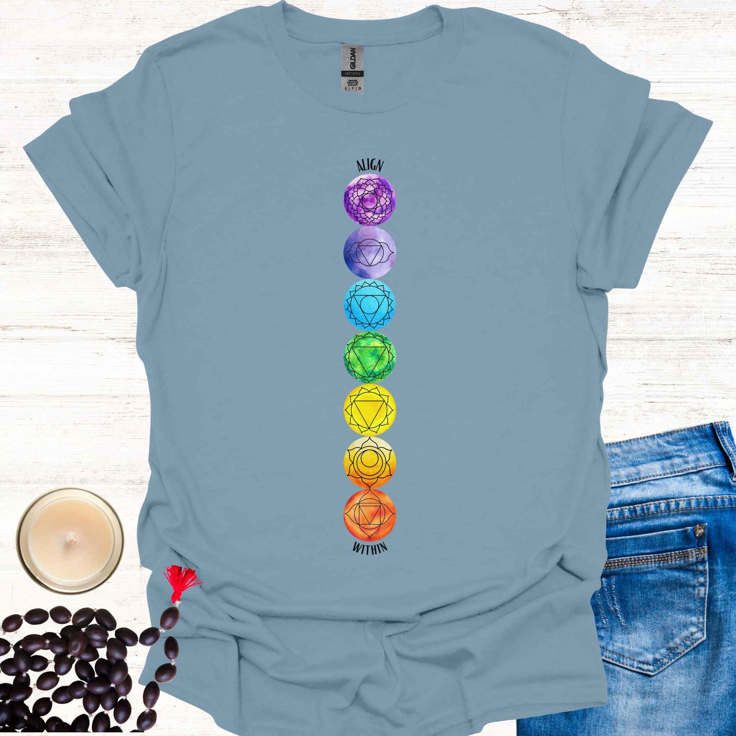Blue t-shirt featuring a colourful, vibrant design of the 7 chakras aligned vertically, each with its corresponding mandala symbol, accompanied by the phrase 'Align Within'. This design represents the energy centers within the body and emphasizes the importance of inner balance and harmony. Rooted in ancient wisdom, it inspires mindfulness, meditation, and self-reflection, aligning with themes of spiritual awakening and holistic well-being. Perfect for yoga practitioners and seekers of wisdom.