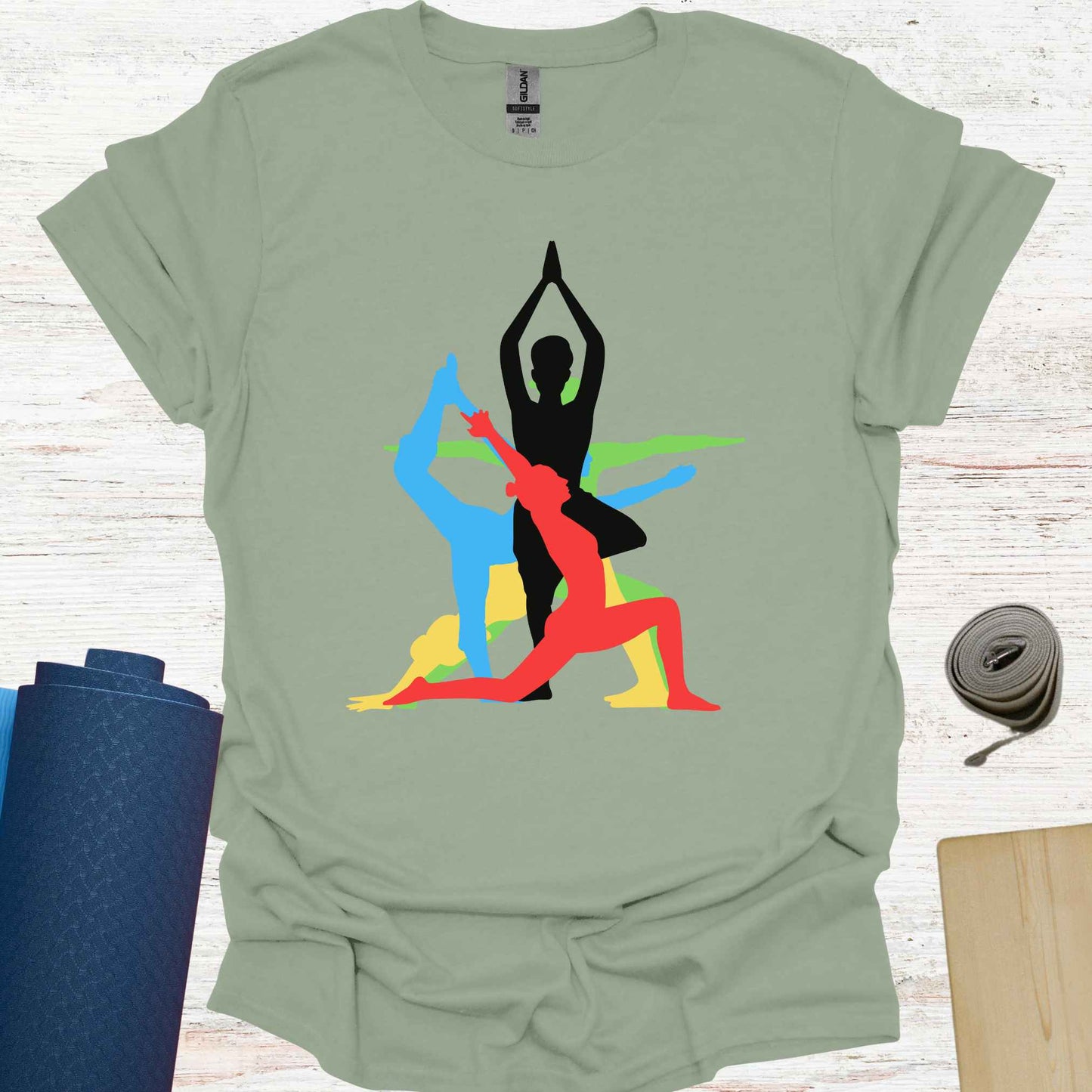 Sage green t-shirt featuring a vibrant graphic of a human form in various overlapping yoga asanas, rendered in different colors. This design captures the fluidity and diversity of yoga, making it a perfect fit for yoga lovers and practitioners who embrace movement, mindfulness, and inner balance.