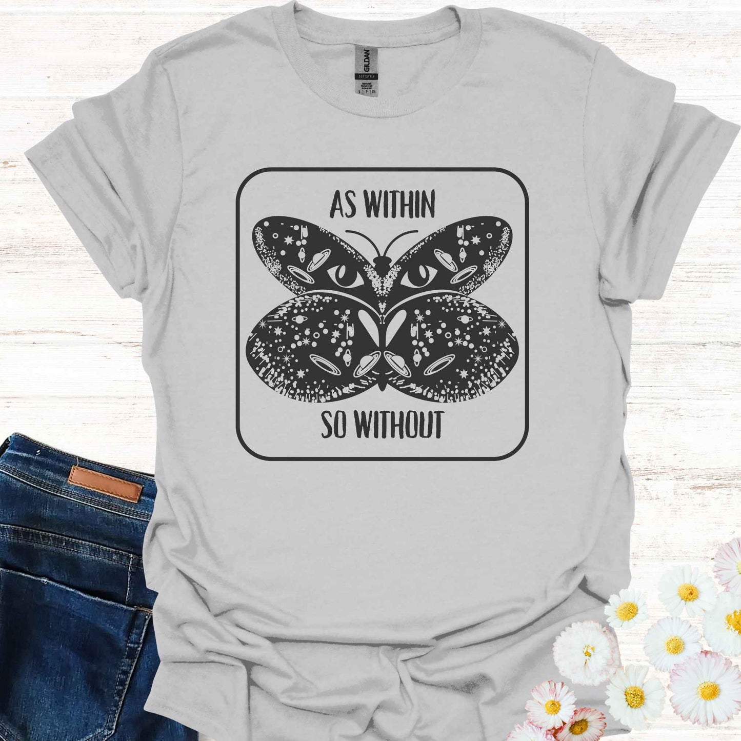 Grey t-shirt featuring a detailed graphic of a butterfly with cosmic and universal symbols on its wings, paired with the philosophical phrase 'As Within So Without.' This design reflects the idea that the external world is a reflection of our inner selves, symbolizing the interconnectedness of the universe and our own universal consciousness.