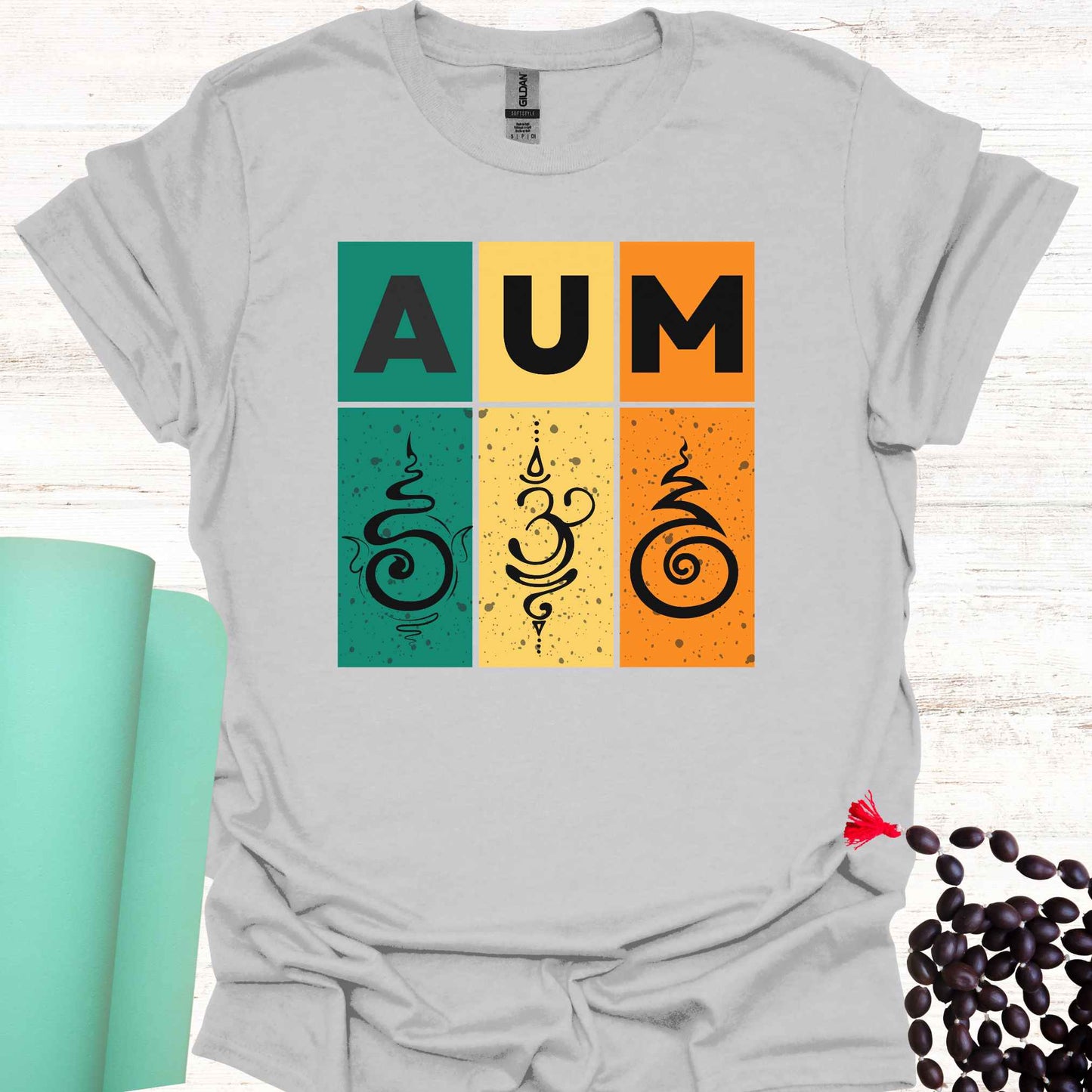 Grey t-shirt with retro sunset-style design with green, yellow, and red bars, bold 'AUM' text, and Sanskrit symbols. Represents the sacred sound AUM, unity, and spiritual essence. The retro aesthetic merges timeless spirituality with modern design, appealing to those who practice meditation, yoga, or seek deeper spiritual awareness.