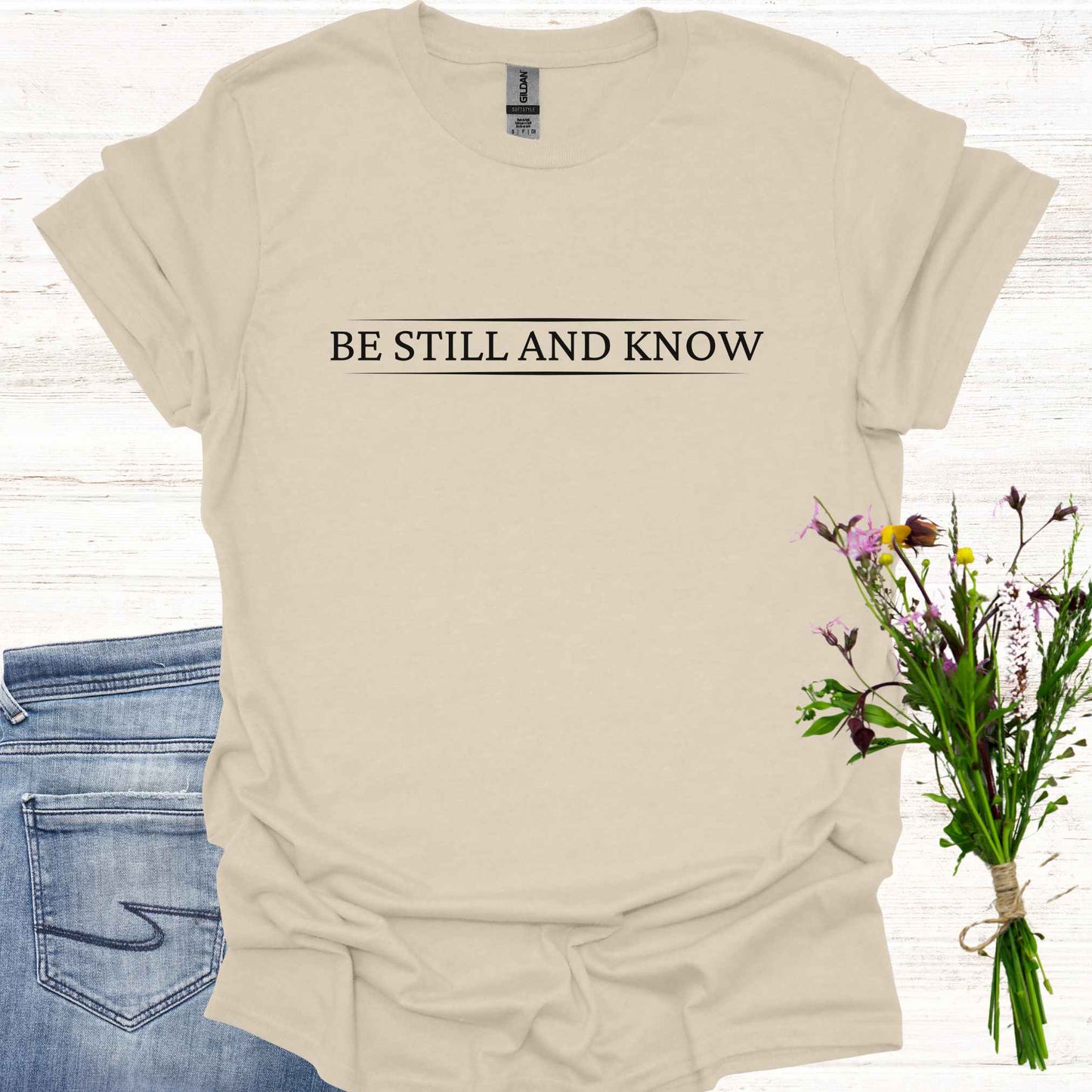 Simple beige t-shirt featuring the spiritual phrase 'Be Still and Know' in clean, minimalist typography. This design encourages inner stillness and self-awareness, reminding meditators and spiritual seekers to find peace within and realize the truth of their being.