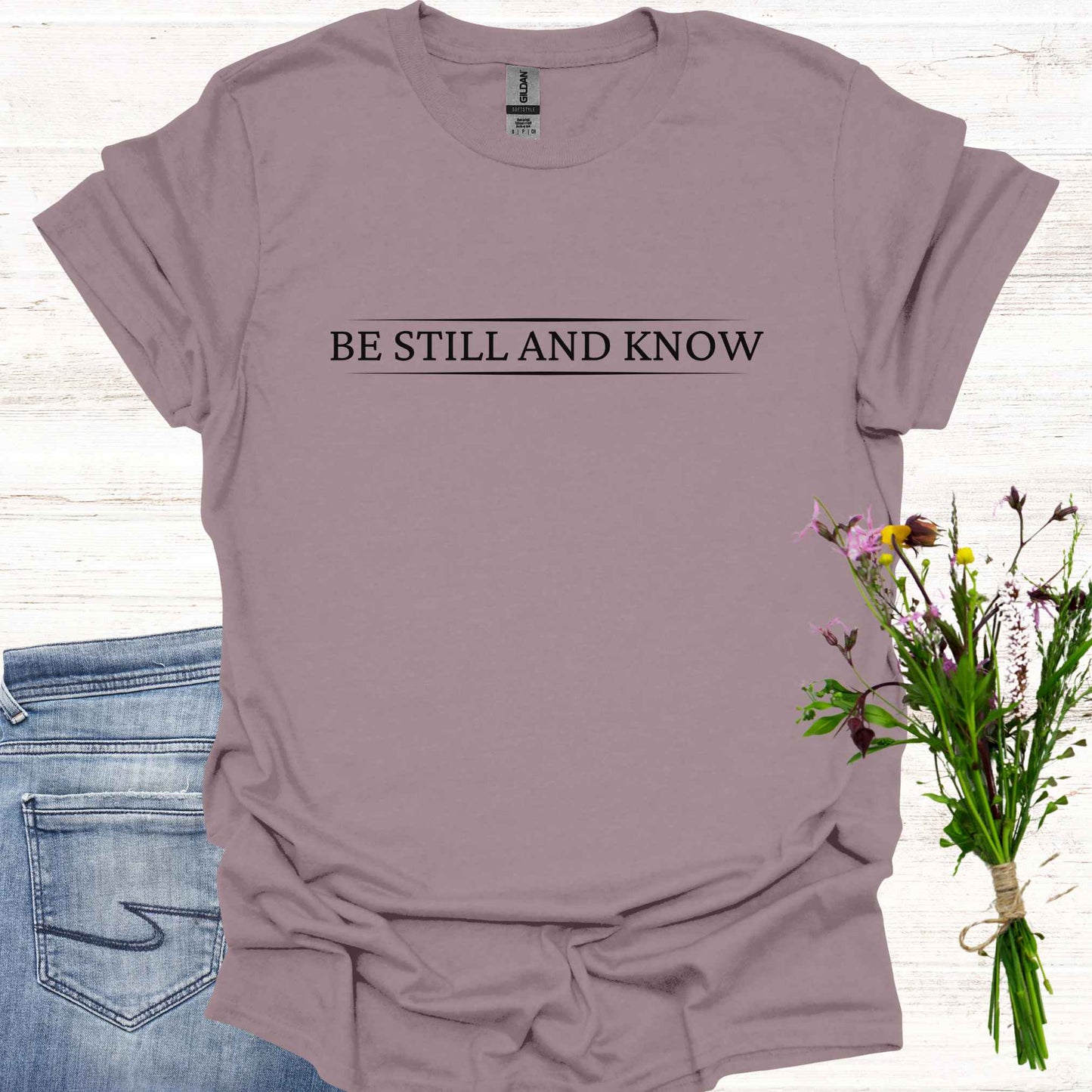 Simple light purple t-shirt featuring the spiritual phrase 'Be Still and Know' in clean, minimalist typography. This design encourages inner stillness and self-awareness, reminding meditators and spiritual seekers to find peace within and realize the truth of their being.