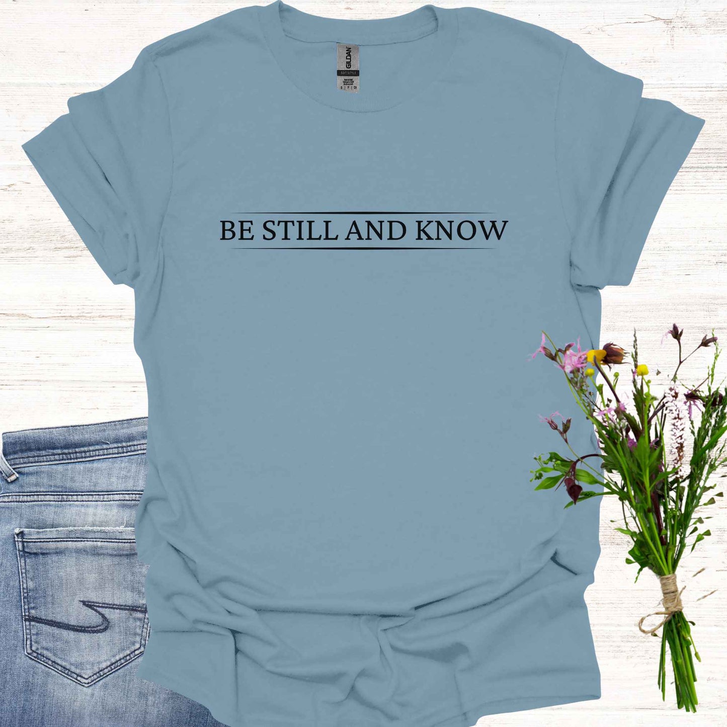 Simple blue t-shirt featuring the spiritual phrase 'Be Still and Know' in clean, minimalist typography. This design encourages inner stillness and self-awareness, reminding meditators and spiritual seekers to find peace within and realize the truth of their being.