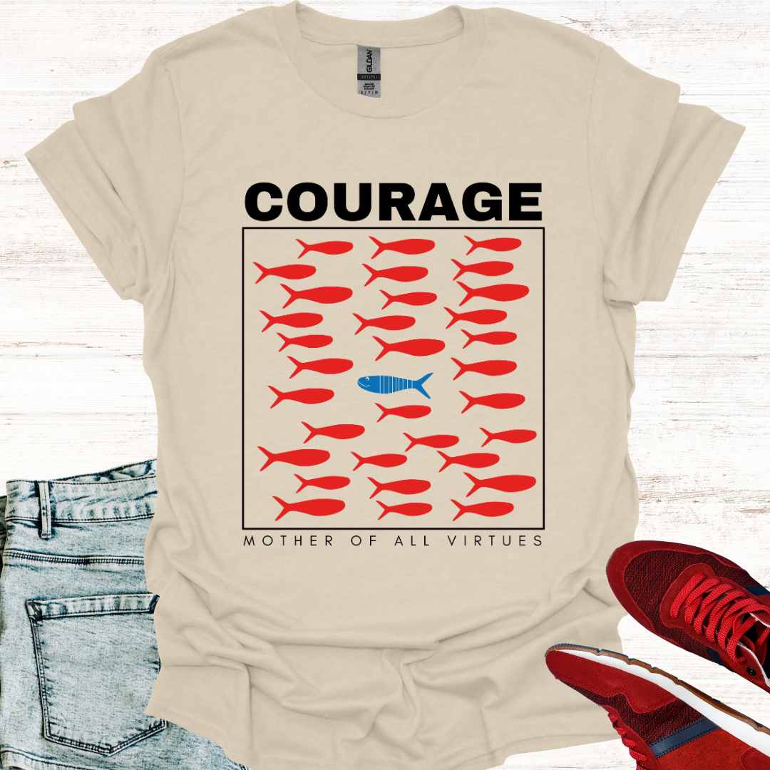Beige t-shirt featuring a design of red fish swimming, with a sole blue fish swimming against the current, symbolizing individuality, perseverance, and the courage to defy societal norms. It is accompanied by the phrase: Courage: Mother of All Virtues. This design is a powerful representation of strength in following your own unique path, even when it means going against the flow. Perfect for those who value independence, resilience, and self-discovery.