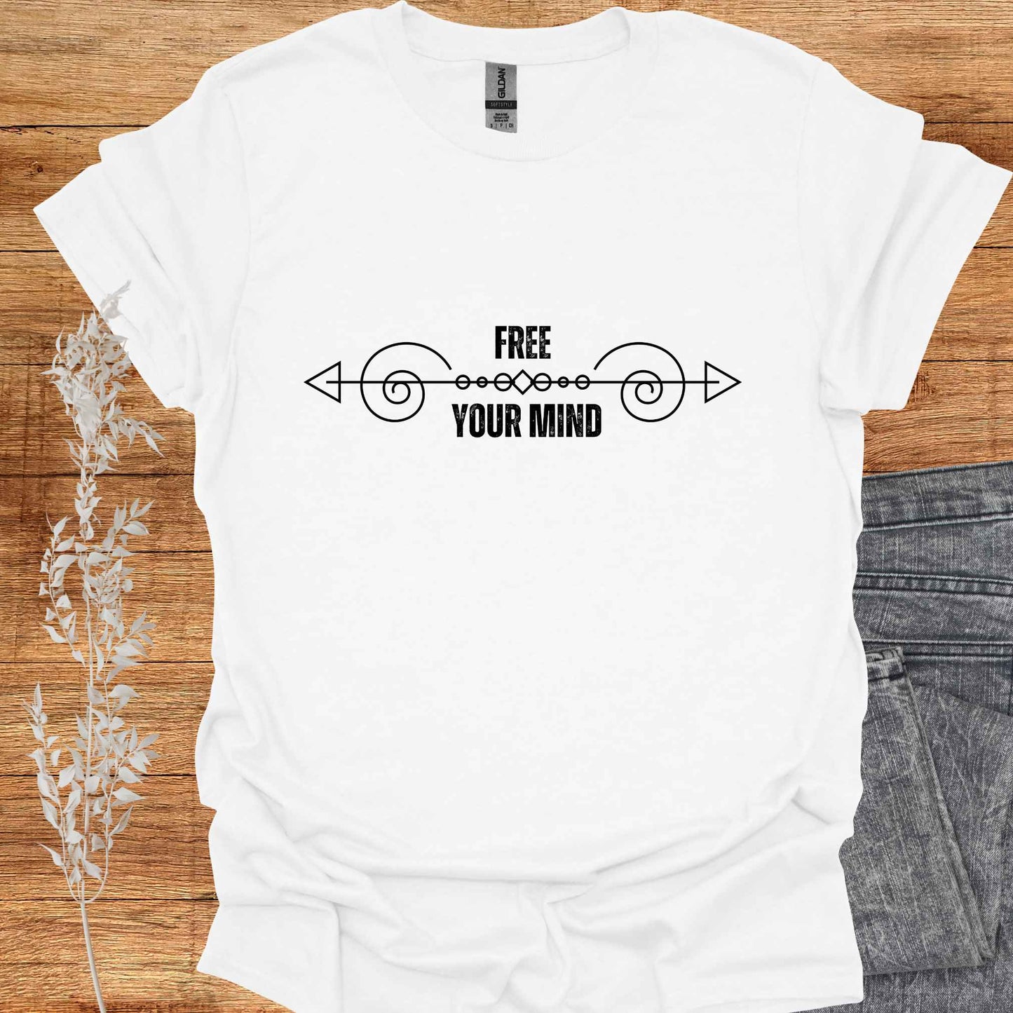 A white t-shirt featuring a design with a horizontal abstract line graphic symbolizing the flow of thought, paired with the phrase "Free Your Mind" in bold, modern typography. This design references the profound spiritual teaching that the mind itself is the only source of limitation and suffering. By transcending the patterns and constraints of the mind, one can experience true freedom, inner peace, and liberation. Perfect for those on a path of self-discovery, mindfulness, and spiritual growth.