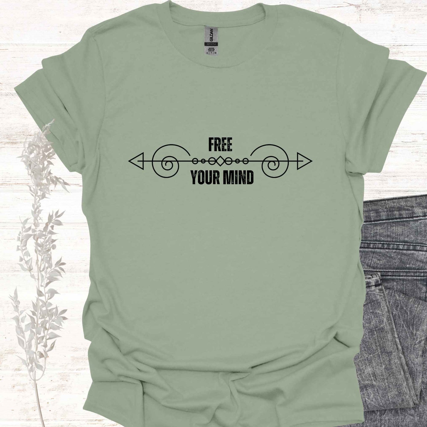 A green t-shirt featuring a design with a horizontal abstract line graphic symbolizing the flow of thought, paired with the phrase "Free Your Mind" in bold, modern typography. This design references the profound spiritual teaching that the mind itself is the only source of limitation and suffering. By transcending the patterns and constraints of the mind, one can experience true freedom, inner peace, and liberation. Perfect for those on a path of self-discovery, mindfulness, and spiritual growth.