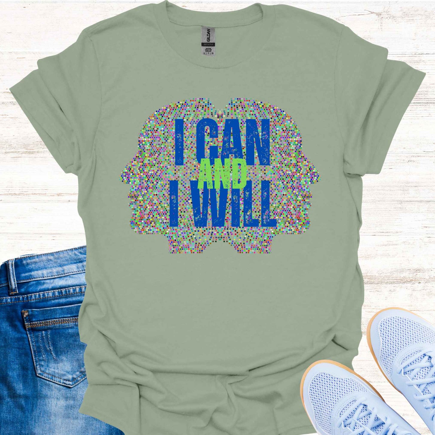 Sage green t-shirt featuring a graphic of two side profiles of faces composed of many small dots, accompanied by the empowering phrase 'I Can and I Will.' This design inspires confidence, positivity, and self-belief, encouraging wearers to overcome challenges and embrace determination. Perfect for individuals seeking motivation and a reminder of their inner strength.