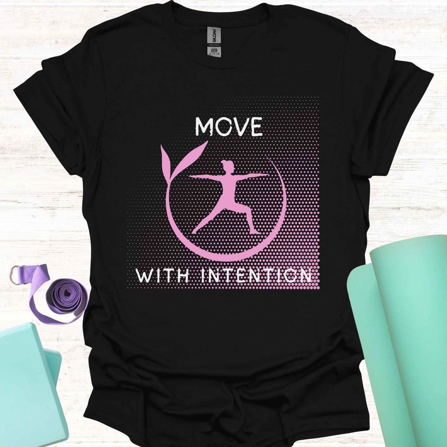 Black t-shirt featuring a pink graphic of a figure in the yogic warrior pose, surrounded by a round frame, with the phrase 'Move with Intention.' This design embodies the central yoga teaching of mindfulness in every action, both on and off the mat. It encourages awareness, focus, and purpose in all movements, promoting balance, strength, and conscious living.