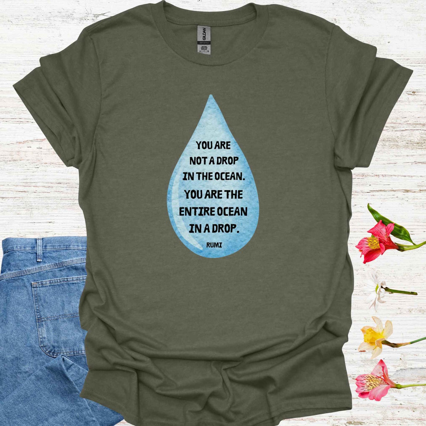 Military green t-shirt featuring design of a watercolor blue drop with the profound Rumi quote: "You are not a drop in the ocean. You are the entire ocean in a drop." The words are elegantly printed within the drop, emphasizing the metaphor of universal consciousness residing within each individual. This design symbolizes the non-dual nature of existence, reminding spiritual seekers and meditators of the infinite potential and interconnectedness within all.