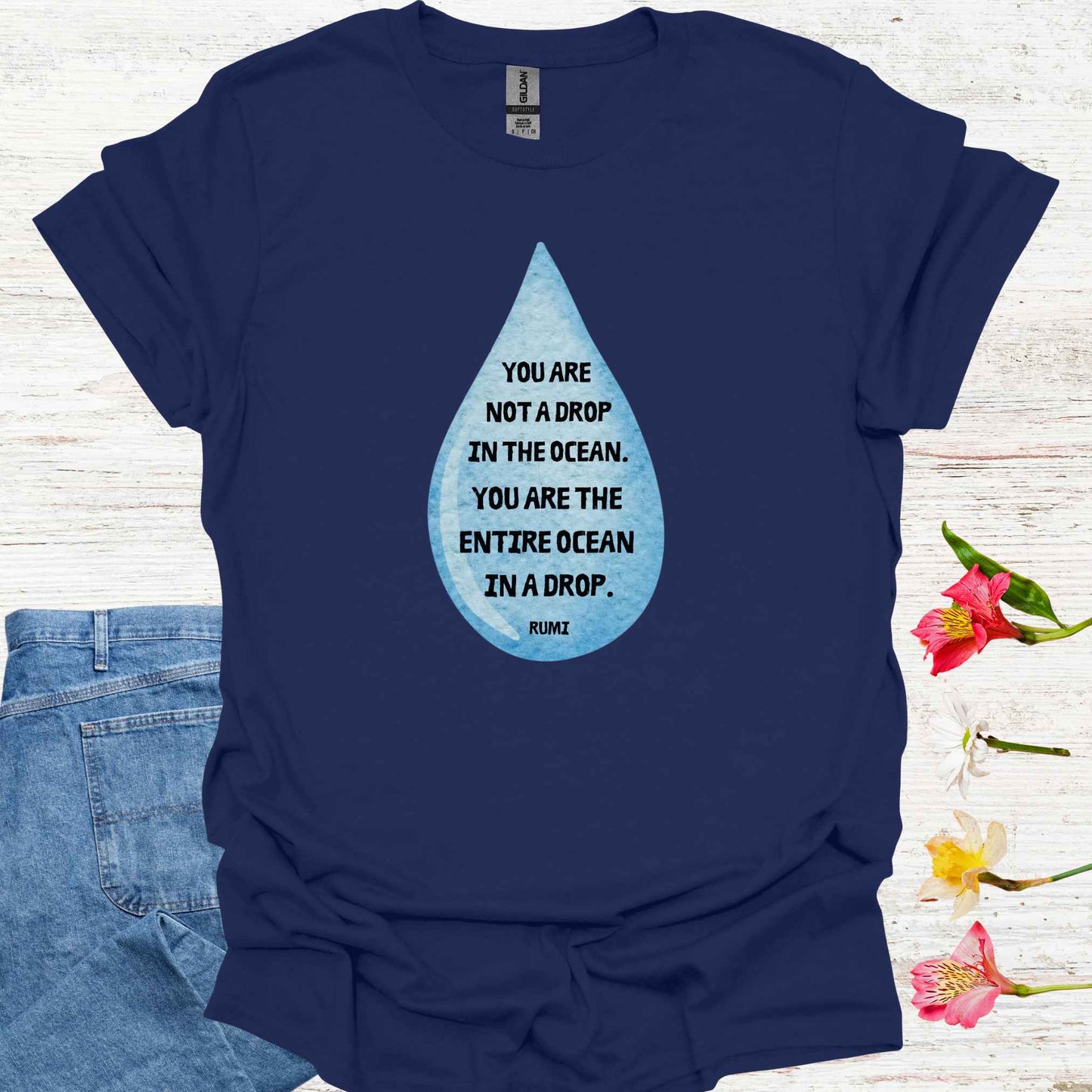 Navy blue t-shirt featuring design of a watercolor blue drop with the profound Rumi quote: "You are not a drop in the ocean. You are the entire ocean in a drop." The words are elegantly printed within the drop, emphasizing the metaphor of universal consciousness residing within each individual. This design symbolizes the non-dual nature of existence, reminding spiritual seekers and meditators of the infinite potential and interconnectedness within all.