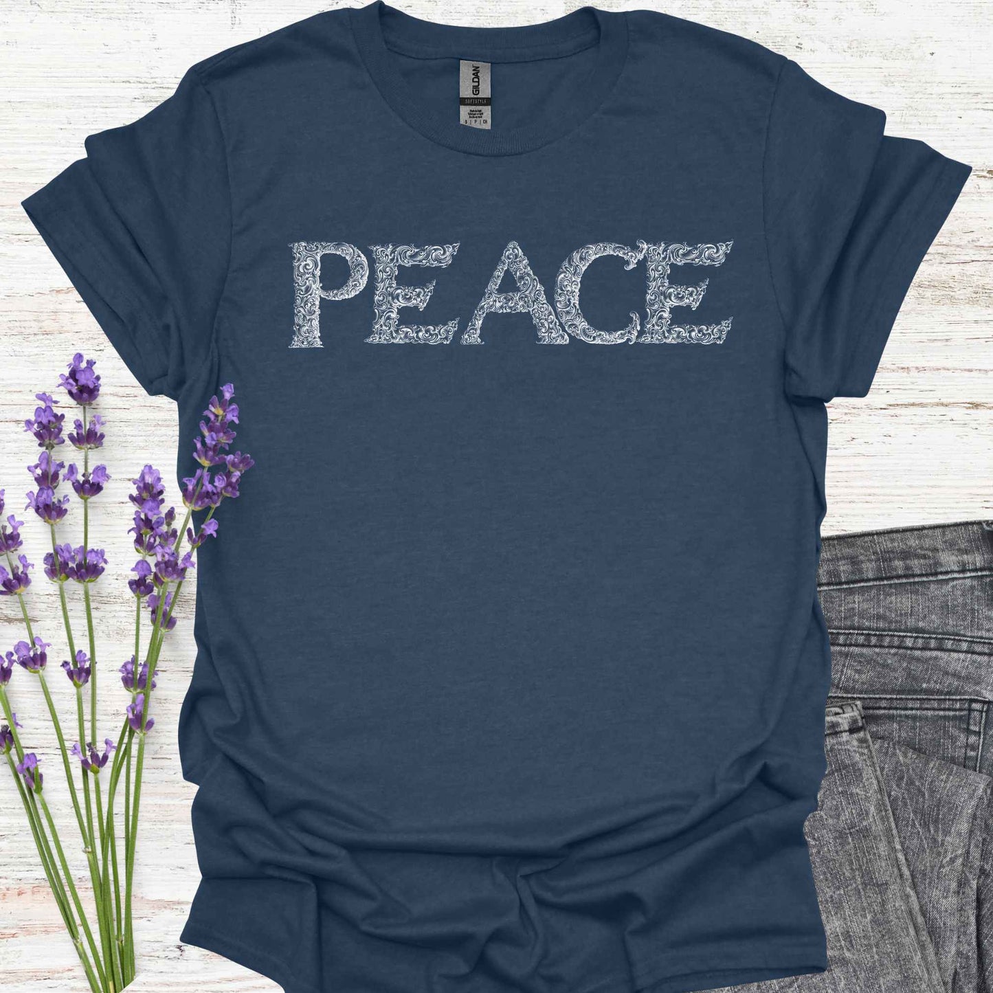 Blue t-shirt with stylized lettering of the word 'Peace' in a unique, artistic font. This design embodies the concept of inner peace, harmony, and tranquility. Perfect for those who value calmness, mindfulness, and positivity. A reminder to cultivate peace within and spread it to the world.