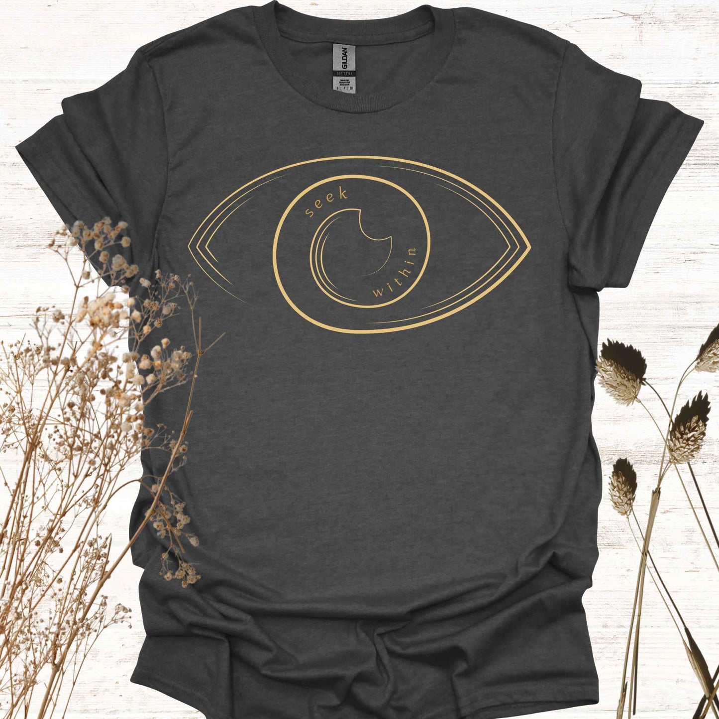 A dark grey t-shirt featuring a line graphic of an eye, with the phrase "Seek Within" placed inside. This design emphasizes the spiritual teaching that truth, peace, and self-realization can be found within one's own consciousness. Inspired by non-duality and self-reflection, it is ideal for spiritual seekers, meditators, and those drawn to introspection and inner wisdom.
