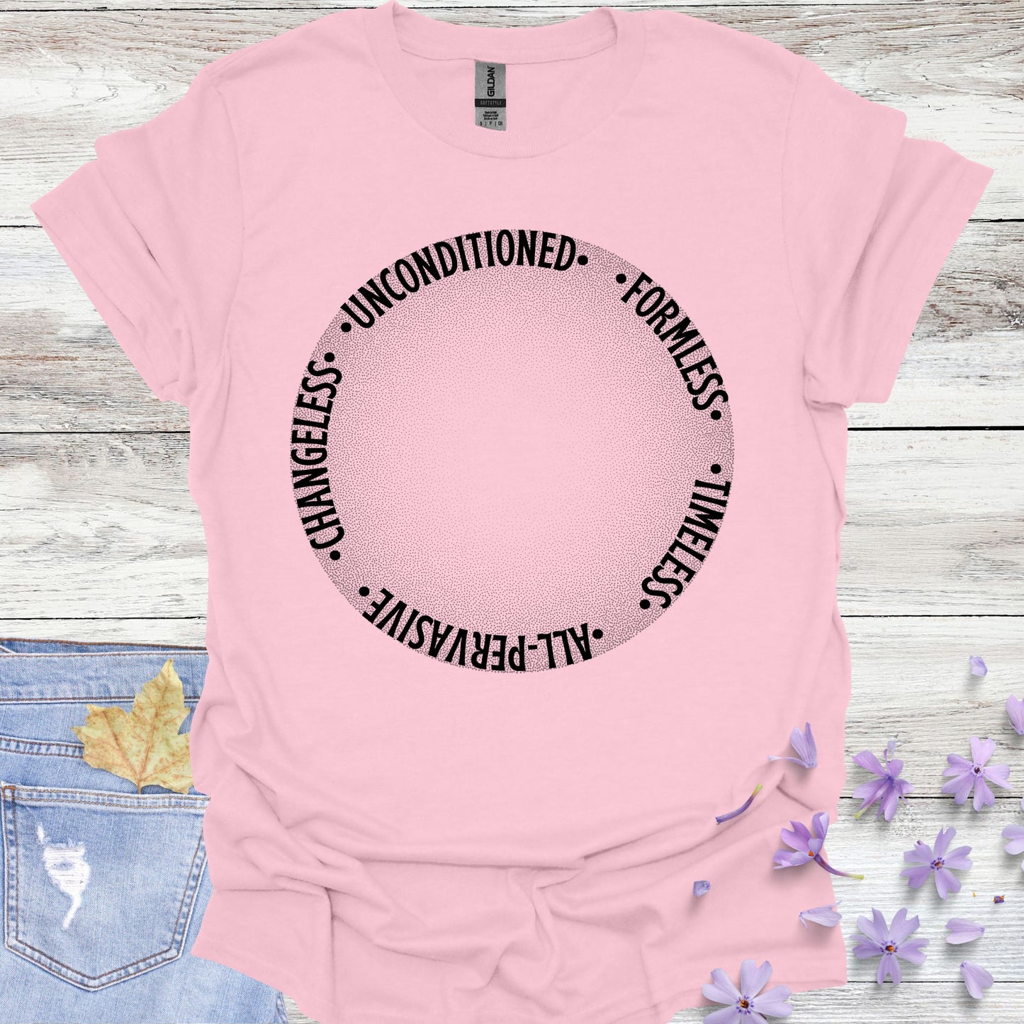 Light pink t-shirt featuring a design with a round gradient background that fades from dark to white at the center. Encircling the inner edges of the circle are the words: 'timeless, all-pervasive, changeless, unconditioned, formless.' The design symbolizes the infinite, eternal nature of awareness, untouched by the limitations of time and space. It reflects the spiritual knowledge of the formless essence that underlies all existence. Ideal for those drawn to meditation, non-duality, and deep introspection.