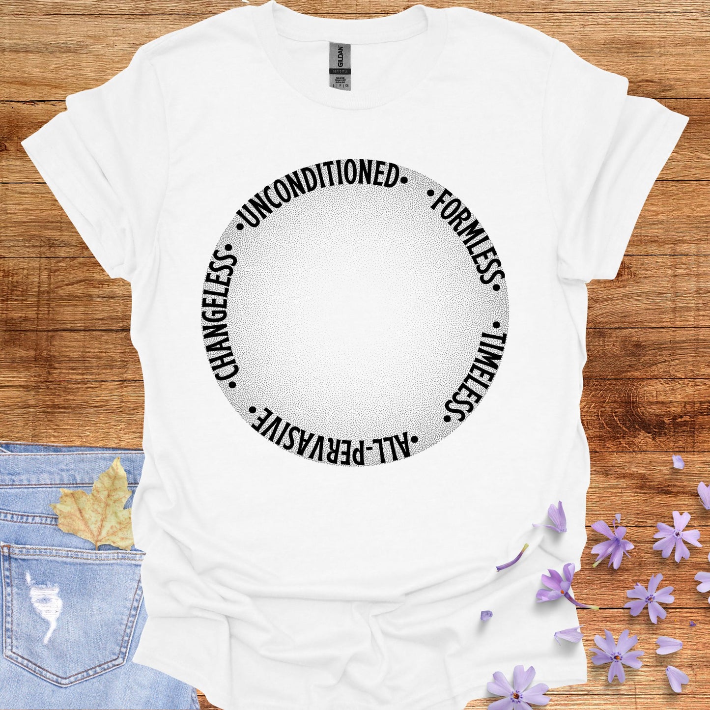 White t-shirt featuring a design with a round gradient background that fades from dark to white at the center. Encircling the inner edges of the circle are the words: 'timeless, all-pervasive, changeless, unconditioned, formless.' The design symbolizes the infinite and eternal nature of awareness, untouched by the limitations of time and space. It reflects the spiritual knowledge of the formless essence that underlies all existence. Ideal for those drawn to meditation, non-duality, and deep introspection.