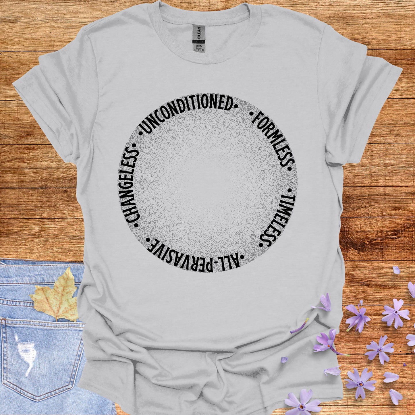 Grey t-shirt featuring a design with a round gradient background that fades from dark to white at the center. Encircling the inner edges of the circle are the words: 'timeless, all-pervasive, changeless, unconditioned, formless.' The design symbolizes the infinite and eternal nature of awareness, untouched by the limitations of time and space. It reflects the spiritual knowledge of the formless essence that underlies all existence. Ideal for those drawn to meditation, non-duality, and deep introspection.
