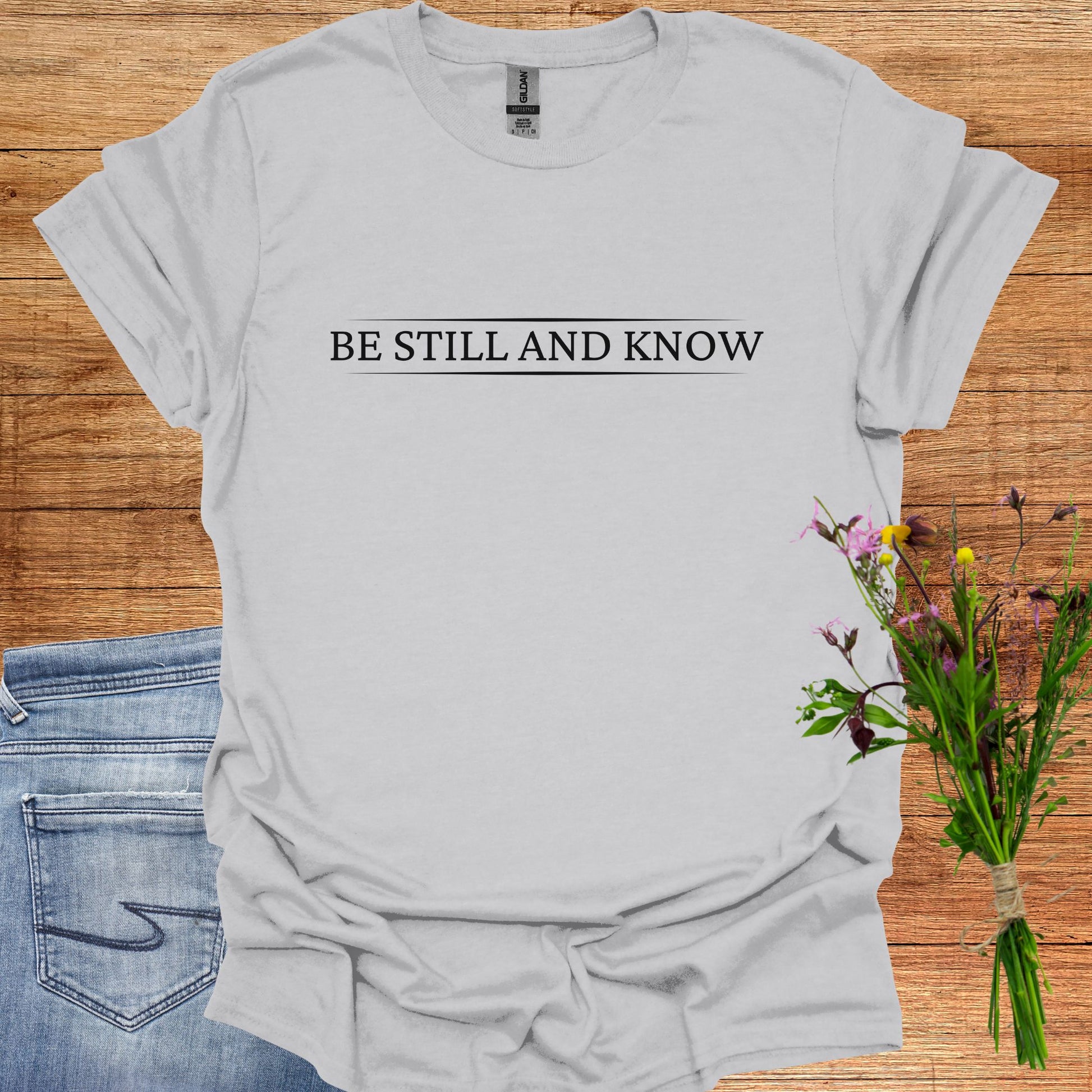 Simple grey t-shirt featuring the spiritual phrase 'Be Still and Know' in clean, minimalist typography. This design encourages inner stillness and self-awareness, reminding meditators and spiritual seekers to find peace within and realize the truth of their being.