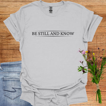 Simple grey t-shirt featuring the spiritual phrase 'Be Still and Know' in clean, minimalist typography. This design encourages inner stillness and self-awareness, reminding meditators and spiritual seekers to find peace within and realize the truth of their being.
