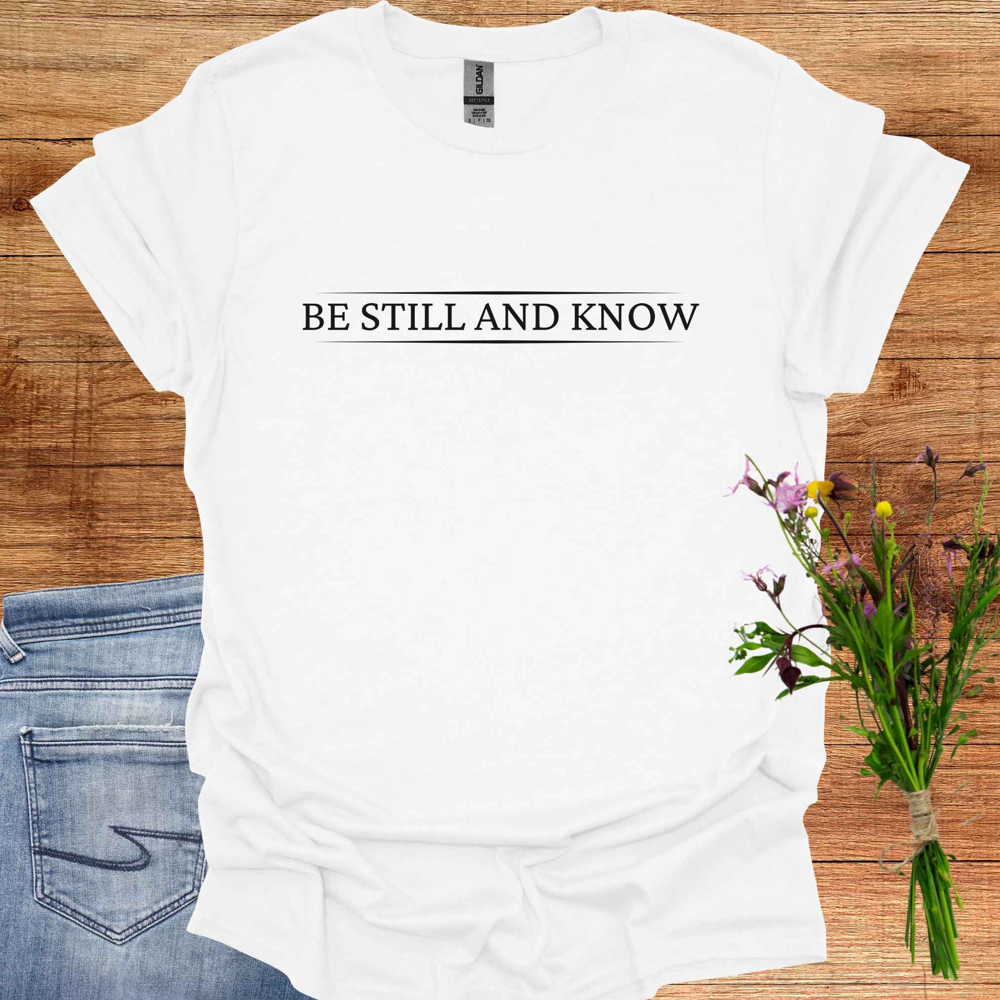 Simple white t-shirt featuring the spiritual phrase 'Be Still and Know' in clean, minimalist typography. This design encourages inner stillness and self-awareness, reminding meditators and spiritual seekers to find peace within and realize the truth of their being.